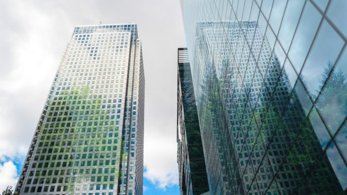 Skyscraper buildings in Canary Wharf with faded out trees over the top of them