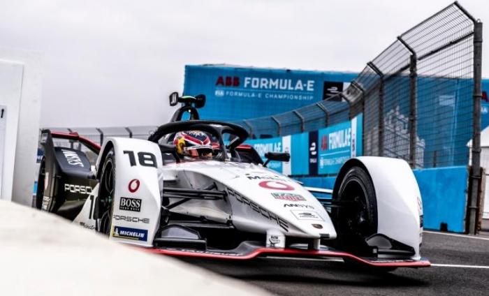 Formula E car racing on a track.