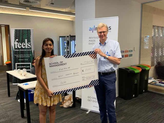 Supriya Rai, left, collects her £1000 cheque from Programme Director Simon Hulme.